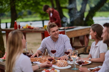 friends having picnic french dinner party outdoor during summer holiday