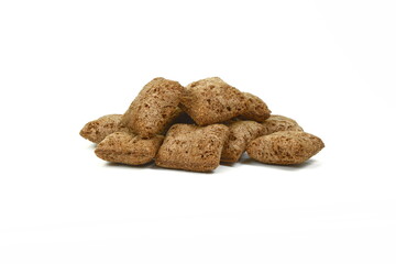 Heap of chocolate pillow cereals isolated on white background. Nougat filled chocolate pillow wafers pile isolated on white background. Crispy chocolate cereal pillow flakes.