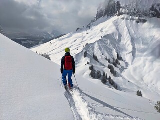 Fototapeta na wymiar skier draws his own track through the powder snow. Freeride in the mountains of glarus on the silbern. mountaineering
