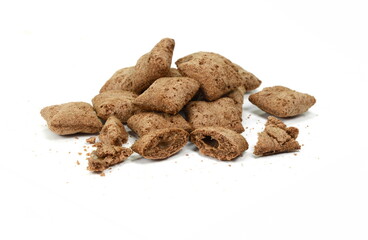 Heap of chocolate pillow cereals isolated on white background. Nougat filled chocolate pillow wafers pile isolated on white background. Crispy chocolate cereal pillow flakes.
