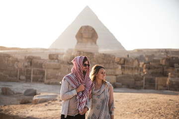 Young Couple in front of the Pyramids of Giza and the Sphinx  - obrazy, fototapety, plakaty