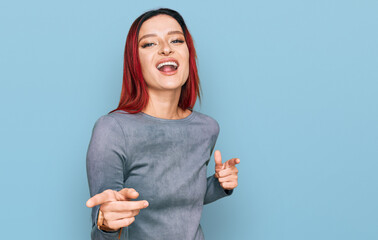 Young caucasian woman wearing casual clothes pointing fingers to camera with happy and funny face. good energy and vibes.