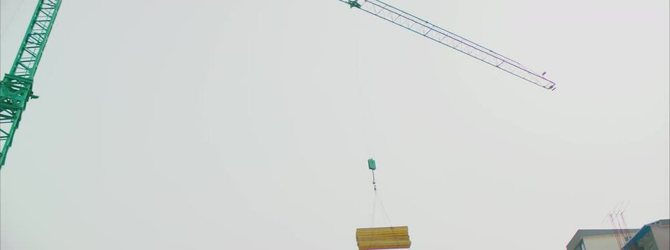 Big green constuction crane on building or construction site in use.