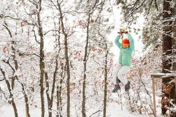 A girl riding a zip line after a fresh snow, Durango, Colorado.
