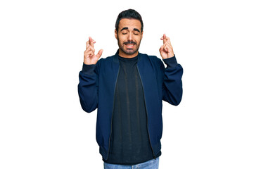 Fototapeta premium Young hispanic man wearing casual clothes gesturing finger crossed smiling with hope and eyes closed. luck and superstitious concept.