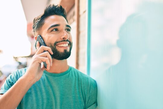 Young arab man with serious expression talking on the smartphone at the city.