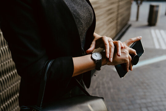 Midsection of businesswoman checking time on wristwatch