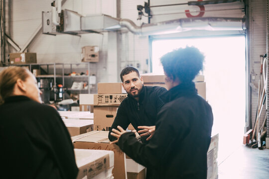 Businesswoman planning strategy with male and female colleagues in warehouse