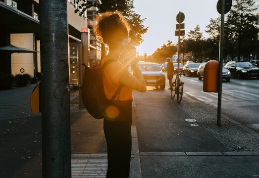 Businesswoman talking over smart phone while standing on footpath in city