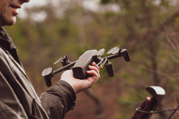 Man with remote control cell phone hold drone.