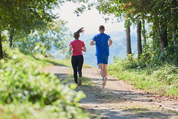 Obraz premium couple enjoying in a healthy lifestyle while jogging on a country road