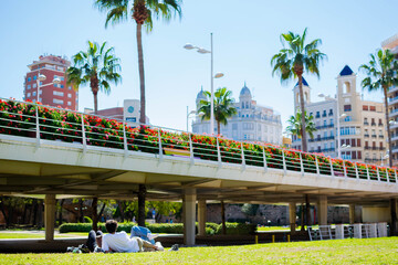 Jóvenes tomando el sol junto a viejo cauce del río Túria (Valencia-España), en un día...