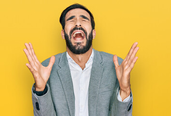 Young hispanic man wearing business clothes celebrating mad and crazy for success with arms raised...