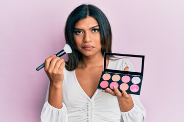 Young latin transsexual transgender woman holding makeup brush and blush palette depressed and worry for distress, crying angry and afraid. sad expression.