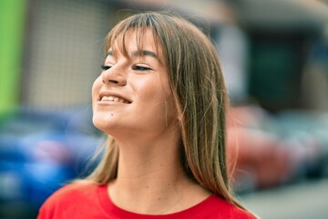 Caucasian teenager girl smiling happy standing at the city.