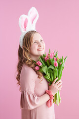 happy stylish girl with long wavy blond hair on pink