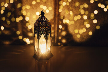 Dark ornamental Moroccan lantern burning at night. Muslim holiday Ramadan Kareem festive blurred...