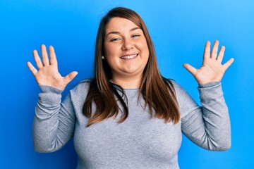 Beautiful brunette plus size woman wearing casual clothes showing and pointing up with fingers...
