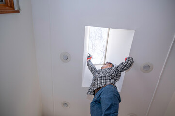 Worker installing moon roof in home
