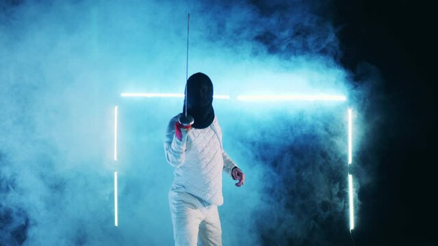 Male athlete is getting ready to the fencing practice
