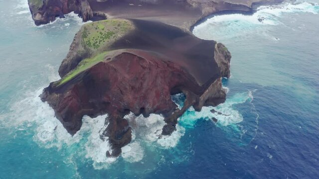 Capelinhos Volcano, Faial Island, Azores, Portugal. Aerial view of steep cliffs washed with blue ocean waters. The magnificent natural heritage with volcanic cliffs. High quality 4k footage