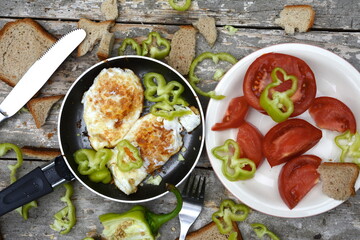 A simple breakfast on the mountain. Traditional healthy easy quick breakfast meal made of two fried eggs served on a frying pan. International simple food, top view.