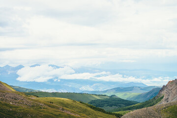 Vivid green landscape with beautiful turquoise mountain lake in sunlight. Impressive sunny scenery with turquoise lake in green mountain valley. Scenic view to beautiful lake among rock in sunny day.