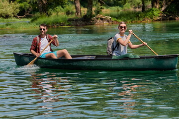 friends are canoeing in a wild river