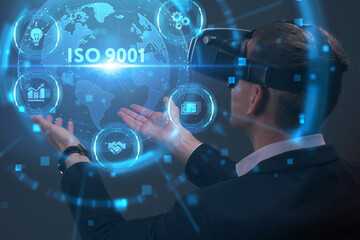 Business, Technology, Internet and network concept. Young businessman working on a virtual screen of the future and sees the inscription: ISO 9001