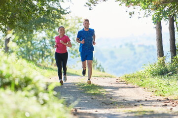 Obraz premium couple enjoying in a healthy lifestyle while jogging on a country road