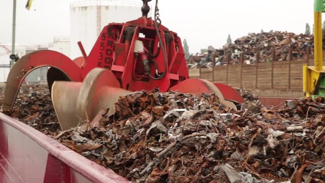 Big metal claw grabs scrap from a train