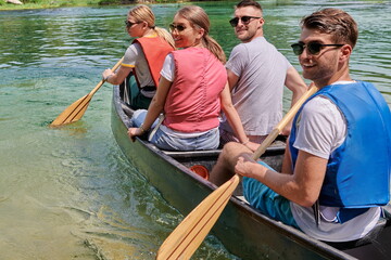 Group adventurous explorer friends are canoeing in a wild river