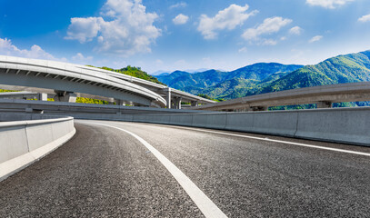 Asphalt road and mountain under the blue sky.