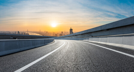 Fototapeta premium Asphalt road and city skyline at sunrise in Shanghai.