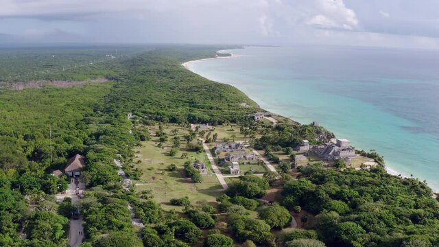 Drone video of ancient historical pyramids by the sea. The buildings of the ancient Mayan civilization in the jungle with temples. Aerial view Tulum Mexico.