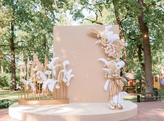 Front view of fashion trendy arch decorated with fresh flowers and other decor. Concept of wedding...