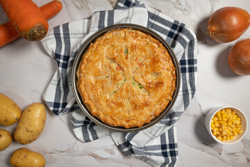 Freshly baked chicken pot pie on a white marble table