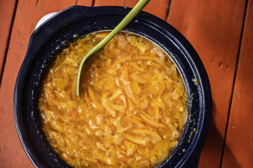 A crockpot pot full of homemade orange marmalade jam.