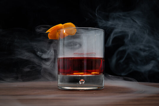 Smoked Negroni on a wooden table with a black background