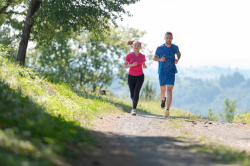 Obraz premium couple enjoying in a healthy lifestyle while jogging on a country road