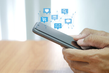 Social media interactions on smart mobile phone. Concept of notification icons of like, message, email and comment. Hands holding the device.
