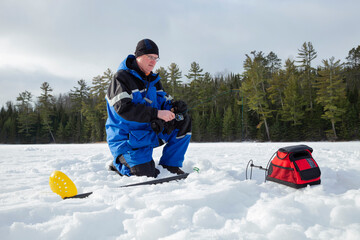 Man ice fishing on a northern Minnesota lake on a winter morning