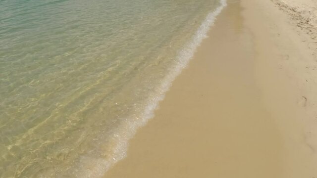 Watching the small waves lap against a golden sand tropical beach.