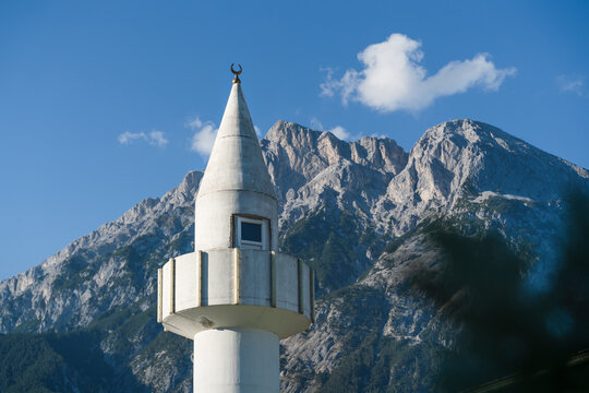 Minaret tower of a mosque in front of sunny Austrian Alps in Telfs, Tirol, Austria