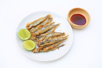Grilled shishamo fish served with lemon and sweet sauce on plate over white background - Japanese food