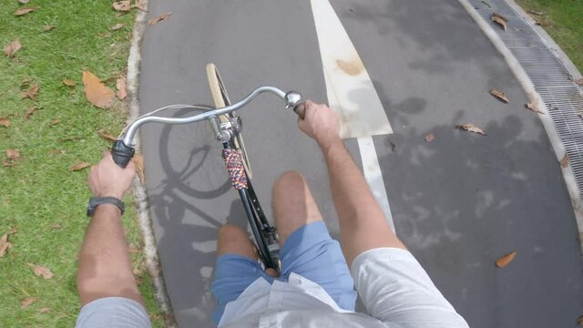 Caucasian Man riding a vintage bicycle riding on a rural bike path, hemet cam POV, no audio.