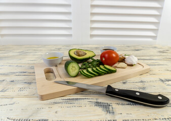 Vegetables on the table and in a basket, tomatoes, cucumbers, avocado, garlic and olive oil, vegetarianism, healthy eating