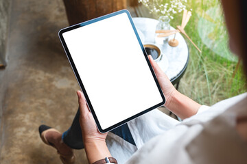 Mockup image of a woman holding digital tablet with blank white desktop screen in cafe