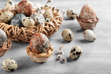 Obraz na płótnie Canvas Easter composition - several marble eggs painted with natural dyes in a wicker nest and baskets