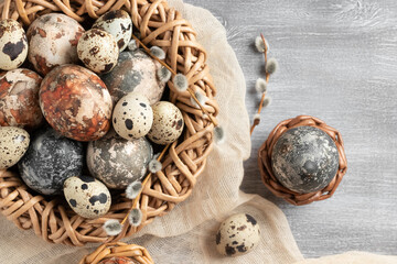 Easter composition - several marble eggs painted with natural dyes in a wicker nest and baskets, top veiw
